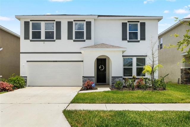 33675 Elm Hill Br, Wesley Chapel, FL 33545 - traditional-style house featuring stucco siding, a garage, stone siding, driveway, and a front yard