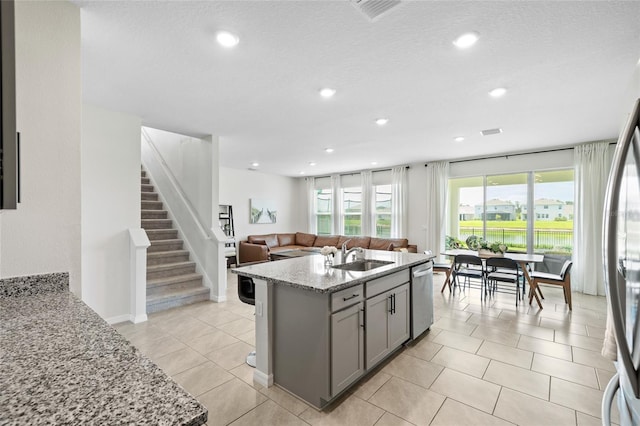33675 Elm Hill Br, Wesley Chapel, FL 33545 - kitchen with gray cabinets, appliances with stainless steel finishes, open floor plan, light stone counters, and recessed lighting