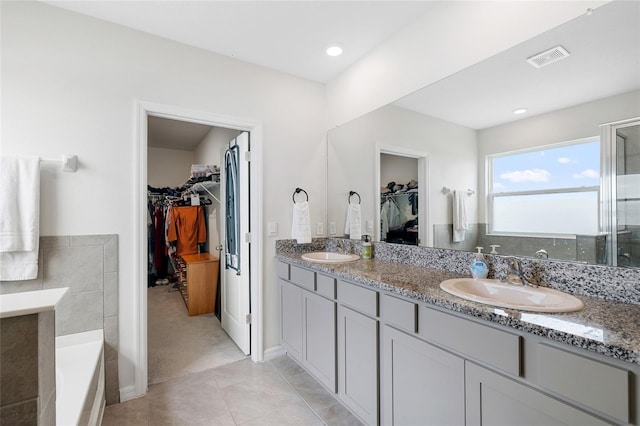33675 Elm Hill Br, Wesley Chapel, FL 33545 - full bathroom with a walk in closet, double vanity, a garden tub, tile patterned flooring, and a stall shower