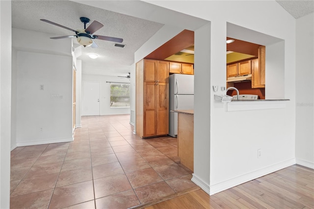 15636 Morning Dr, Lutz, FL 33559 - kitchen with freestanding refrigerator, a ceiling fan, a textured ceiling, and under cabinet range hood