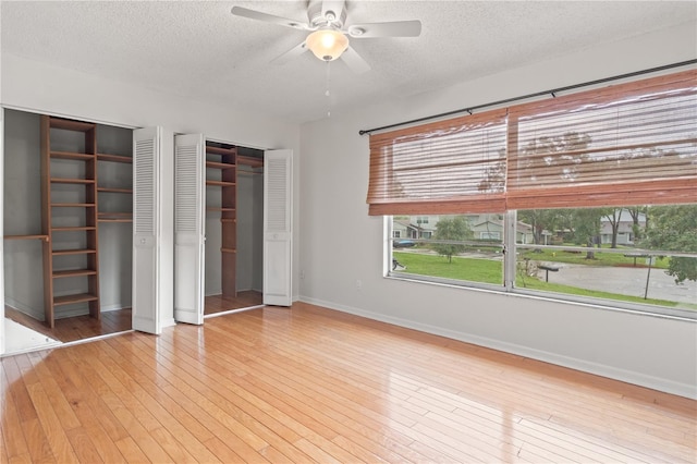 15636 Morning Dr, Lutz, FL 33559 - unfurnished bedroom featuring a textured ceiling, multiple closets, hardwood / wood-style flooring, and a ceiling fan