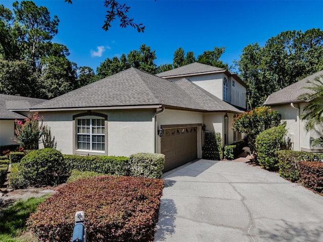 5224 Fairway One Dr, Valrico, FL 33596 - view of front of house featuring stucco siding, roof with shingles, a garage, and concrete driveway