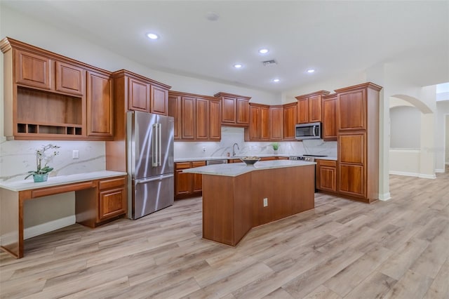 5224 Fairway One Dr, Valrico, FL 33596 - kitchen with stainless steel appliances, a center island, arched walkways, light countertops, and tasteful backsplash