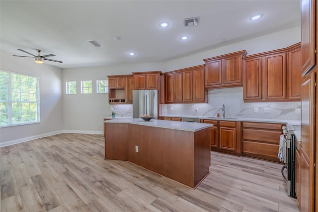 5224 Fairway One Dr, Valrico, FL 33596 - kitchen featuring appliances with stainless steel finishes, light countertops, brown cabinets, a kitchen island, and a ceiling fan