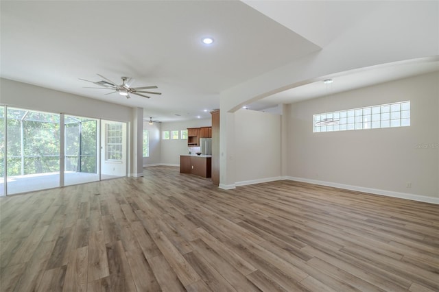 5224 Fairway One Dr, Valrico, FL 33596 - unfurnished living room with a ceiling fan, light wood finished floors, arched walkways, and recessed lighting