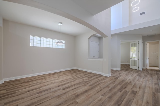 5224 Fairway One Dr, Valrico, FL 33596 - empty room with wood finished floors, arched walkways, and a chandelier
