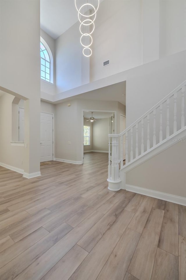 5224 Fairway One Dr, Valrico, FL 33596 - entrance foyer featuring a high ceiling, healthy amount of natural light, wood finished floors, stairway, and ceiling fan