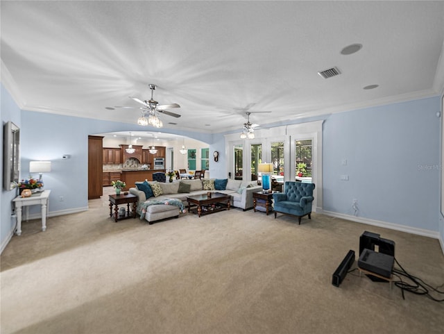 7427 20th St, Zephyrhills, FL 33540 - living room featuring a ceiling fan, light colored carpet, ornamental molding, and arched walkways