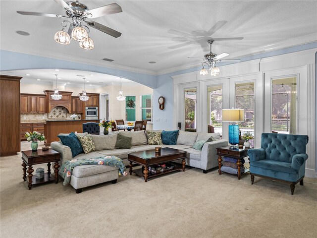 7427 20th St, Zephyrhills, FL 33540 - living room with light colored carpet, arched walkways, ceiling fan, and ornamental molding