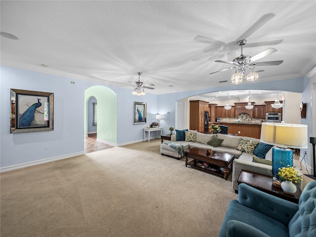 7427 20th St, Zephyrhills, FL 33540 - living area featuring a ceiling fan, arched walkways, light colored carpet, crown molding, and a textured ceiling