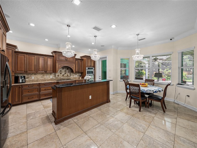 7427 20th St, Zephyrhills, FL 33540 - kitchen featuring black appliances, a chandelier, decorative backsplash, a center island, and crown molding