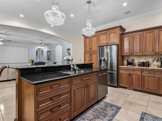 7427 20th St, Zephyrhills, FL 33540 - kitchen featuring arched walkways, appliances with stainless steel finishes, open floor plan, a chandelier, and brown cabinetry