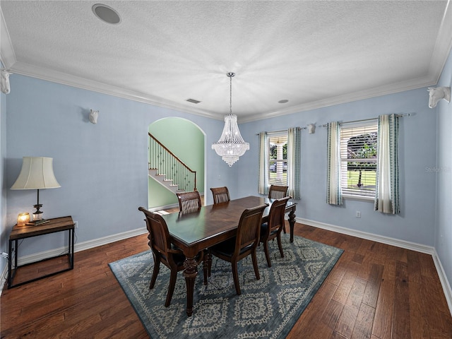 7427 20th St, Zephyrhills, FL 33540 - dining area featuring a textured ceiling, a chandelier, dark wood-style flooring, crown molding, and arched walkways