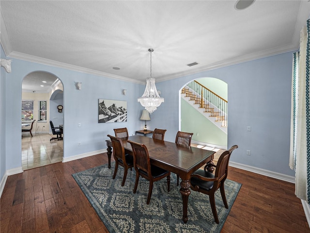7427 20th St, Zephyrhills, FL 33540 - dining area featuring arched walkways, wood-type flooring, ornamental molding, a chandelier, and stairs