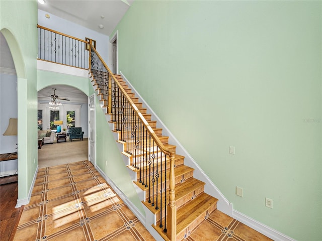 7427 20th St, Zephyrhills, FL 33540 - stairs with arched walkways, ceiling fan, a towering ceiling, and tile patterned floors