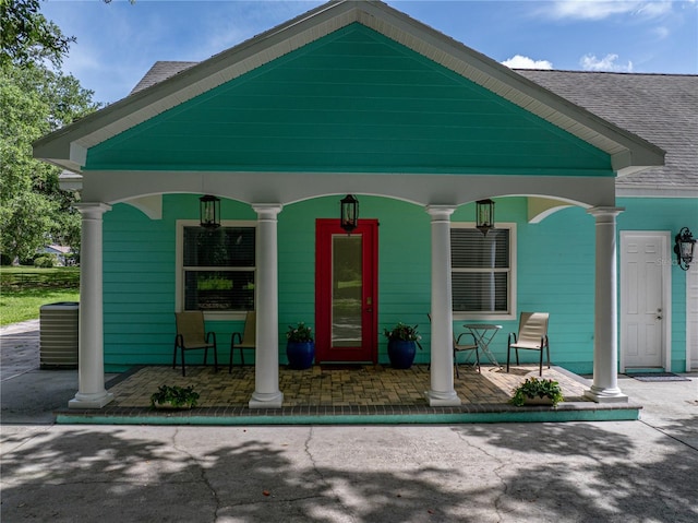 7427 20th St, Zephyrhills, FL 33540 - view of exterior entry with covered porch and roof with shingles