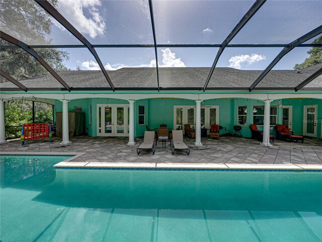 7427 20th St, Zephyrhills, FL 33540 - back of house with french doors, a patio area, roof with shingles, an outdoor pool, and glass enclosure