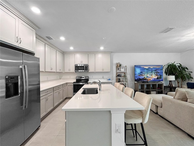 5336 Patano Loop, Palmetto, FL 34221 - kitchen featuring appliances with stainless steel finishes, gray cabinets, a breakfast bar, open floor plan, and light countertops