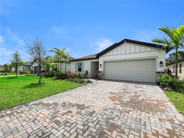 5336 Patano Loop, Palmetto, FL 34221 - ranch-style house featuring an attached garage, a front lawn, decorative driveway, stone siding, and stucco siding