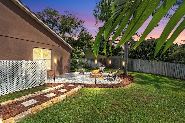 9206 Brindlewood Dr, Odessa, FL 33556 - yard at dusk featuring a fenced backyard, a patio area, and a fire pit