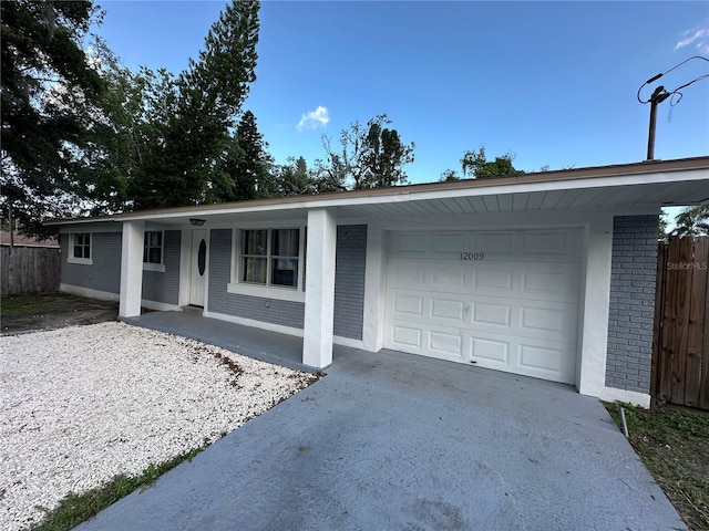 12009 Washington St, Seffner, FL 33584 - ranch-style house featuring an attached garage, concrete driveway, brick siding, and covered porch