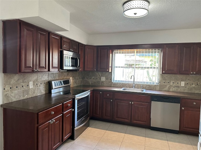 12009 Washington St, Seffner, FL 33584 - kitchen featuring appliances with stainless steel finishes, dark countertops, decorative backsplash, and a textured ceiling