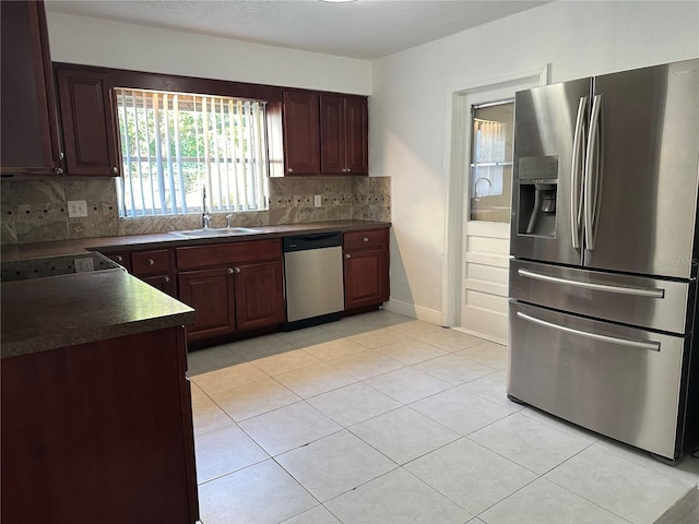 12009 Washington St, Seffner, FL 33584 - kitchen featuring appliances with stainless steel finishes, dark countertops, tasteful backsplash, and light tile patterned floors