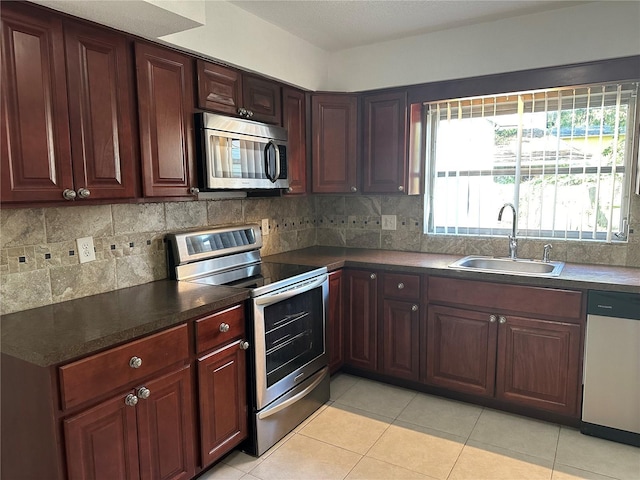 12009 Washington St, Seffner, FL 33584 - kitchen with appliances with stainless steel finishes, tasteful backsplash, dark countertops, and light tile patterned flooring
