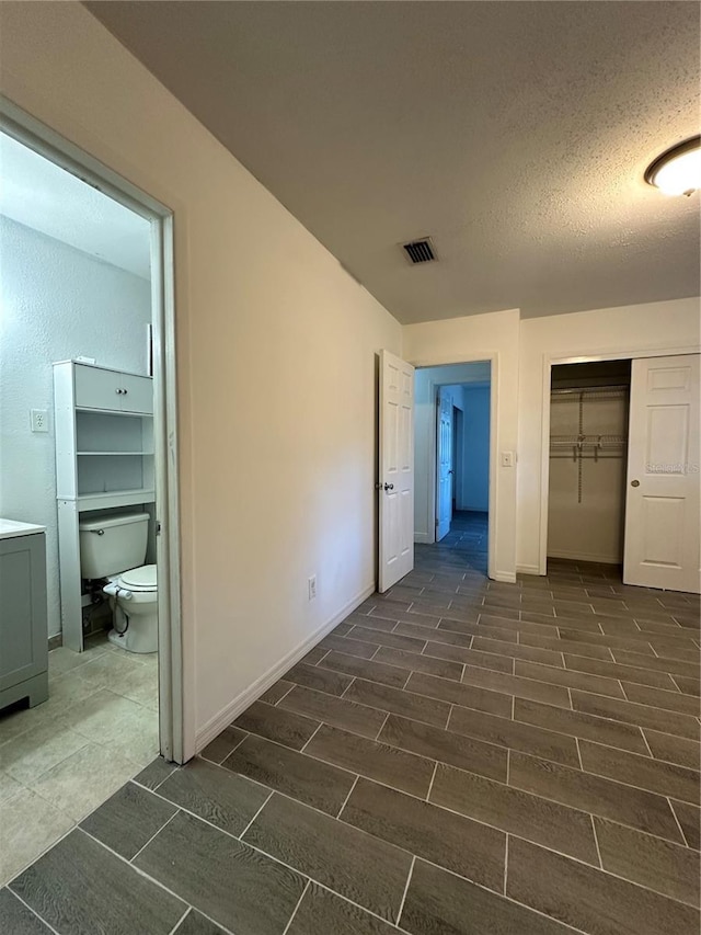 12009 Washington St, Seffner, FL 33584 - unfurnished bedroom with a closet, a textured ceiling, and dark wood-style floors
