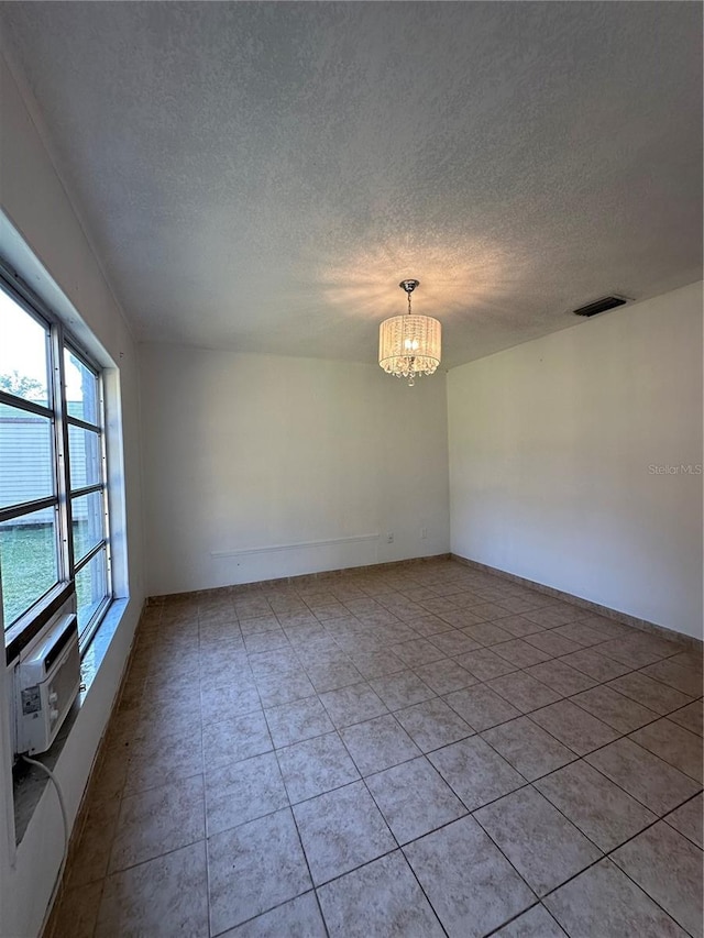12009 Washington St, Seffner, FL 33584 - spare room with a textured ceiling, a chandelier, light tile patterned flooring, and cooling unit