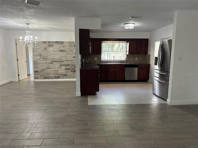 12009 Washington St, Seffner, FL 33584 - kitchen featuring stainless steel appliances, dark countertops, a chandelier, tasteful backsplash, and a textured ceiling