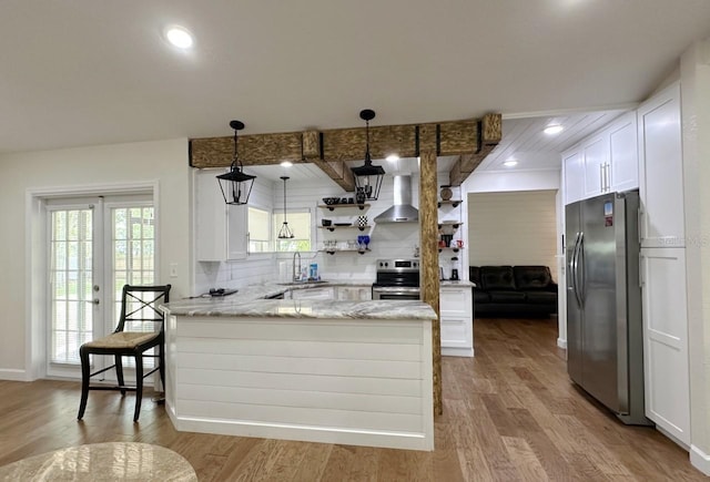 1548 Foxboro Dr, Palm Harbor, FL 34683 - kitchen with stainless steel appliances, wall chimney exhaust hood, a peninsula, white cabinets, and recessed lighting