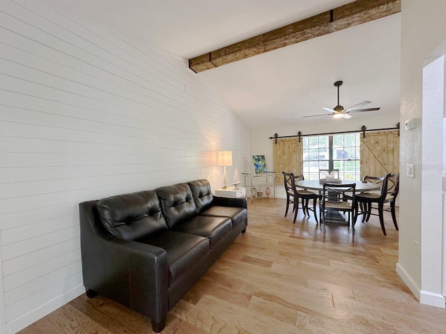 1548 Foxboro Dr, Palm Harbor, FL 34683 - living area featuring a barn door, light wood-style flooring, ceiling fan, and wood walls