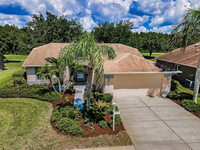 1115 Ashbourne Cir, Trinity, FL 34655 - view of front of property featuring an attached garage, concrete driveway, stucco siding, and a front lawn