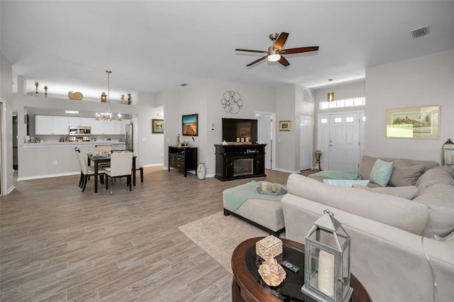 1115 Ashbourne Cir, Trinity, FL 34655 - living area featuring a chandelier, a ceiling fan, and light wood-style floors