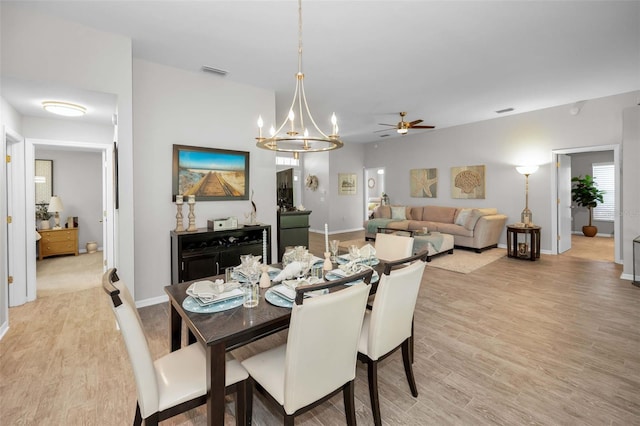 1115 Ashbourne Cir, Trinity, FL 34655 - dining space with a ceiling fan, light wood-style floors, and a chandelier