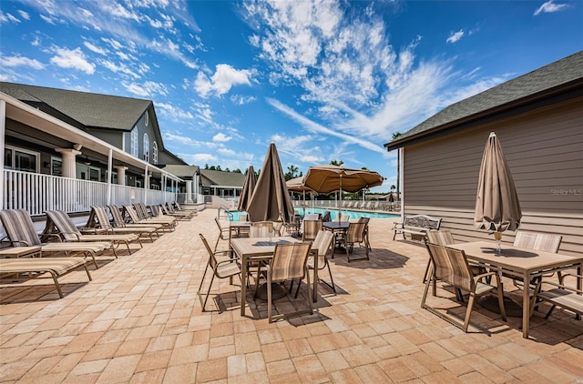 1115 Ashbourne Cir, Trinity, FL 34655 - view of patio with a community pool and outdoor dining area