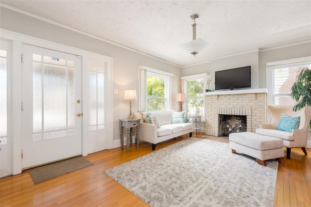 3611 W Bay To Bay Blvd, Tampa, FL 33611 - living room featuring ornamental molding, wood finished floors, plenty of natural light, a fireplace, and a textured ceiling