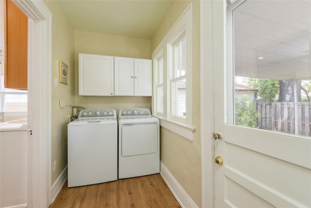 3611 W Bay To Bay Blvd, Tampa, FL 33611 - laundry room with cabinet space, light wood-style flooring, and washing machine and clothes dryer