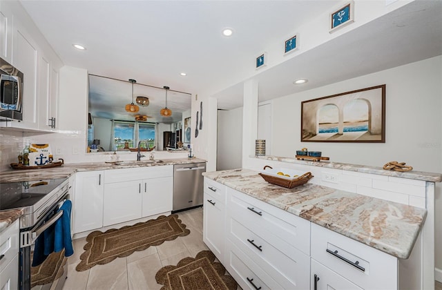 1324 Pasadena Ave S Unit 501, South Pasadena, FL 33707 - kitchen with stainless steel appliances, light stone counters, light tile patterned flooring, white cabinets, and recessed lighting
