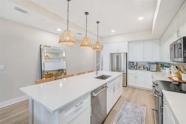 400 150th Ave Unit 504, Madeira Beach, FL 33708 - kitchen featuring stainless steel appliances, an island with sink, light wood-style flooring, backsplash, and recessed lighting