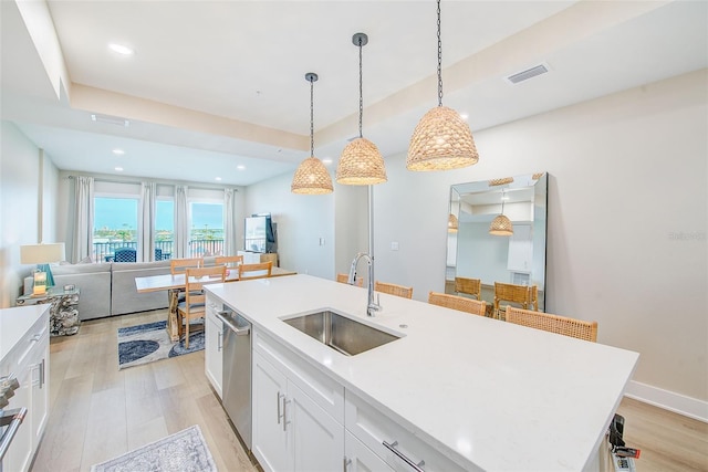 400 150th Ave Unit 504, Madeira Beach, FL 33708 - kitchen with light wood-style floors, white cabinetry, stainless steel dishwasher, pendant lighting, and light countertops