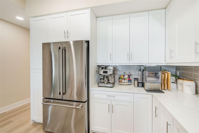 400 150th Ave Unit 504, Madeira Beach, FL 33708 - kitchen with high end refrigerator, light countertops, tasteful backsplash, white cabinetry, and recessed lighting