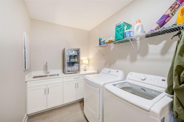 400 150th Ave Unit 504, Madeira Beach, FL 33708 - washroom featuring independent washer and dryer, cabinet space, and light wood finished floors