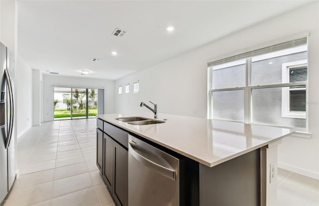 10426 Cross River Trl, Parrish, FL 34219 - kitchen featuring stainless steel appliances, a center island with sink, light tile patterned floors, light countertops, and open floor plan