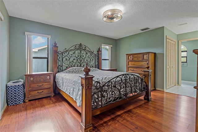8671 Cypress Lakes Blvd, New Port Richey, FL 34653 - bedroom featuring wood finished floors, a textured ceiling, and a closet