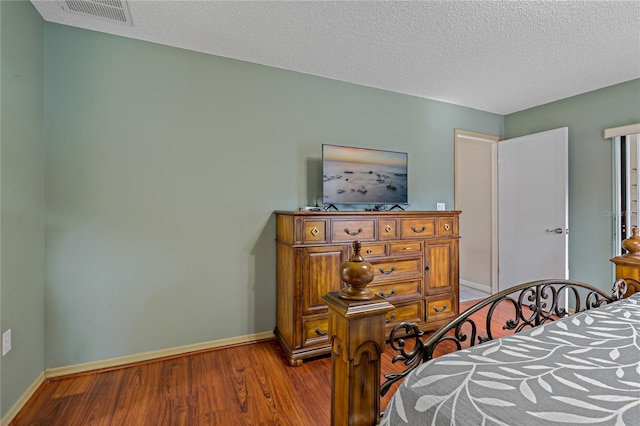 8671 Cypress Lakes Blvd, New Port Richey, FL 34653 - bedroom with wood finished floors and a textured ceiling