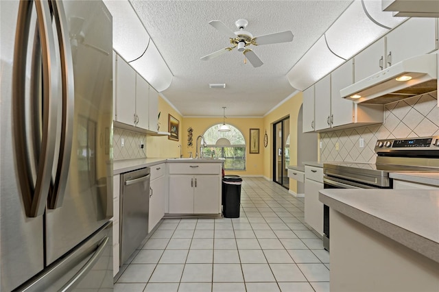 8671 Cypress Lakes Blvd, New Port Richey, FL 34653 - kitchen with appliances with stainless steel finishes, under cabinet range hood, a peninsula, a textured ceiling, and light tile patterned flooring