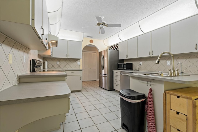 8671 Cypress Lakes Blvd, New Port Richey, FL 34653 - kitchen with stainless steel appliances, a ceiling fan, tasteful backsplash, light tile patterned floors, and light countertops