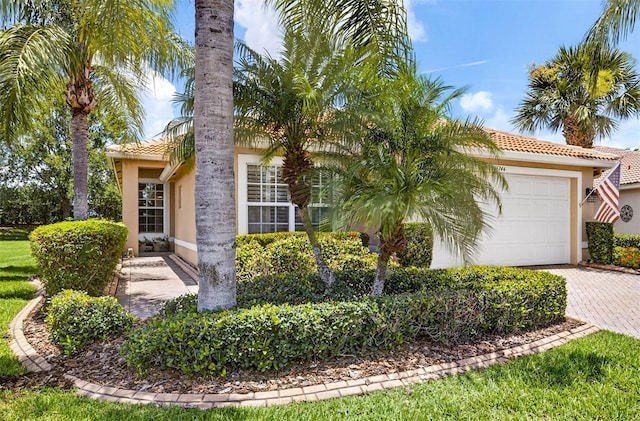 15744 Crystal Waters Dr, Wimauma, FL 33598 - obstructed view of property with stucco siding, a tile roof, an attached garage, and decorative driveway
